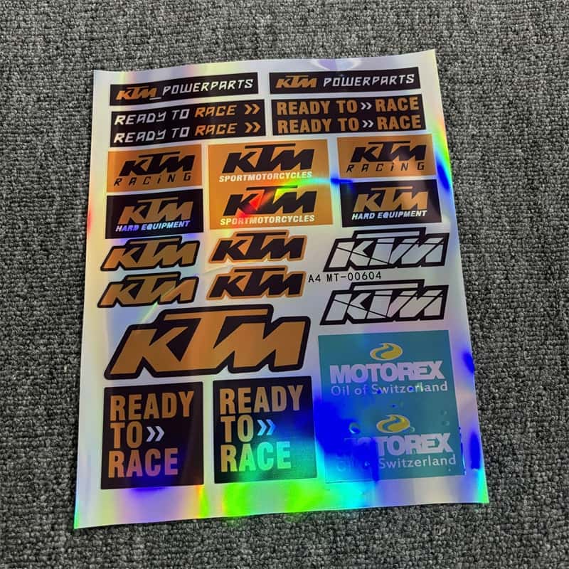 Holographic sticker sheet featuring KTM Powerparts, "Ready To Race" designs, and Motorex branding, great for customizing KTM motorcycles.