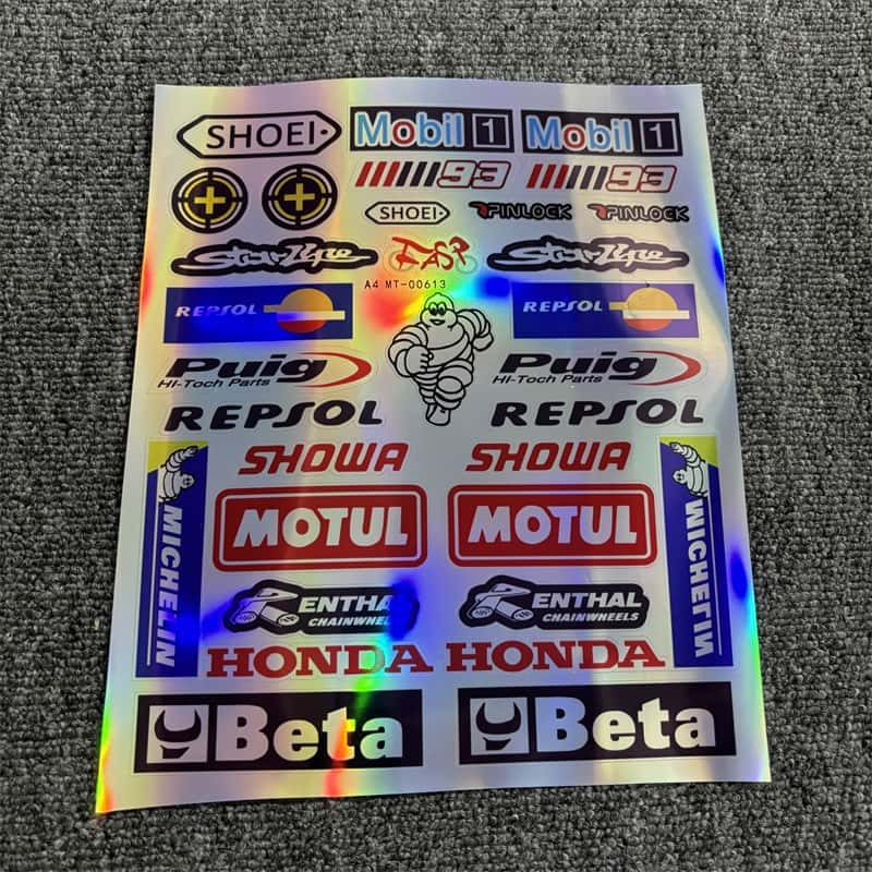 Holographic sticker sheet with motorcycle racing brands like Motul, Honda, Michelin, Repsol, and Beta, ideal for customizing motorcycles and vehicles.