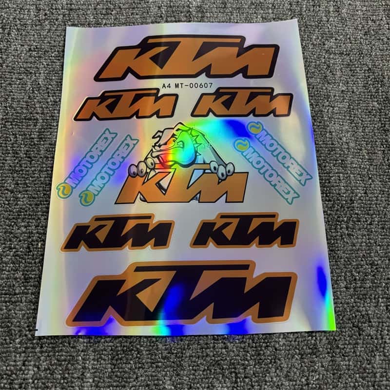 Laser sticker sheet with multiple KTM logos and Motorex branding, ideal for customizing KTM motorcycles to showcase a racing - inspired style with laser visual effects.