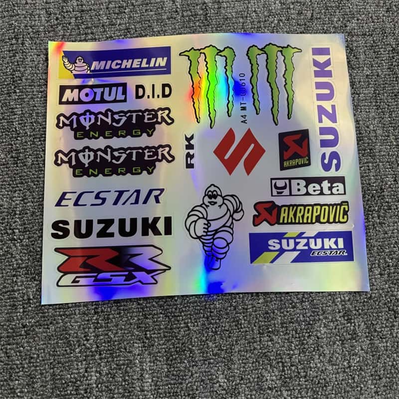 Laser sticker sheet with multiple Suzuki logos, Monster Energy branding, and Akrapovic designs, ideal for customizing Suzuki motorcycles to showcase a racing - inspired style.